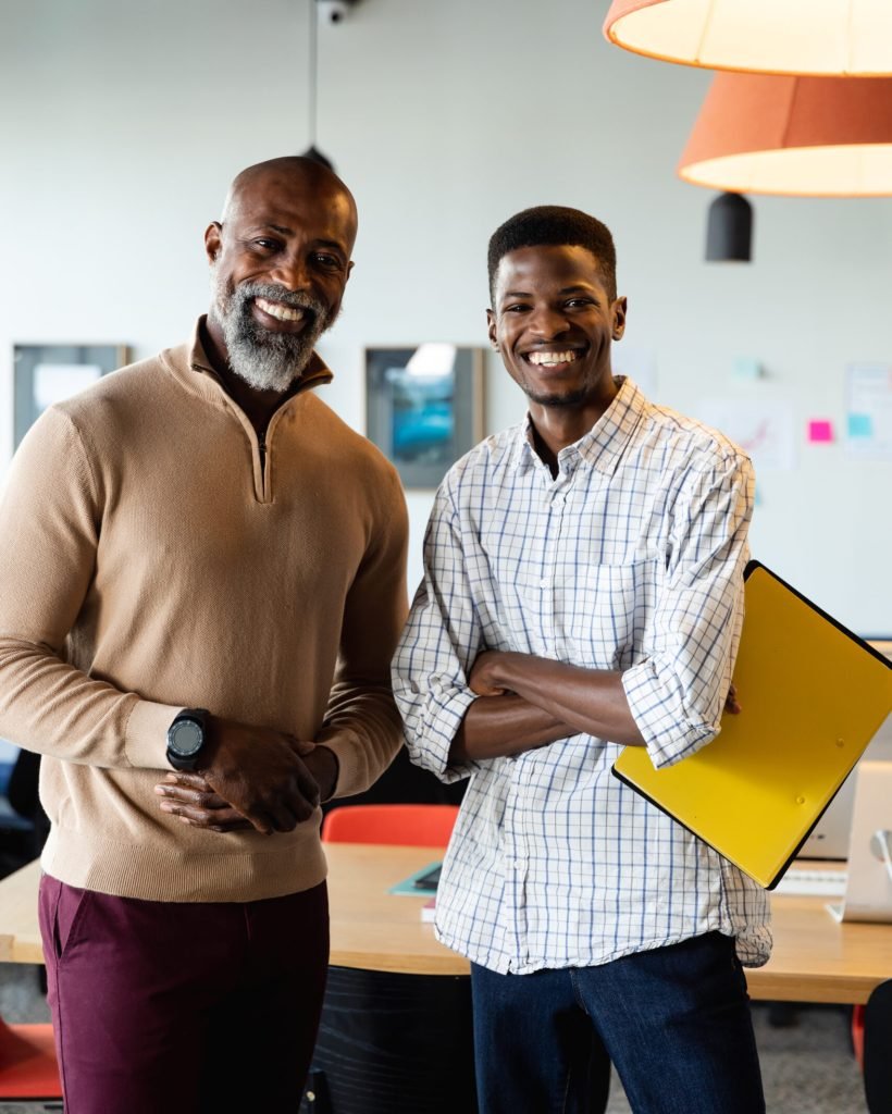 Portrait of smiling african american businessmen in creative office. Unaltered, creative business, workplace, occupation, teamwork, positive emotion.